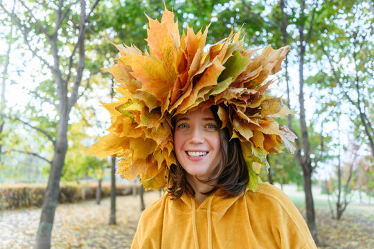 Happy woman wearing autumn wreath on head