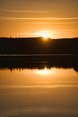 Sunset with reflection on a Swedish lake in Smalland. Romantic evening mood