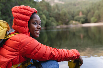 Smiling woman sitting in front of lake