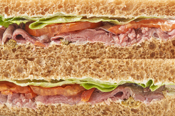 Delicious stuffed layer of ham and veggies in brown bread sandwich