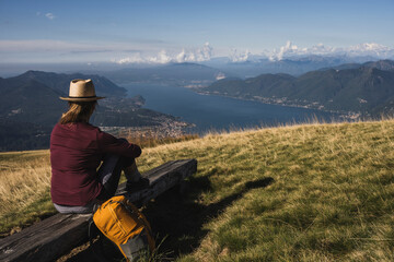 Mature woman sitting on bench in front of mountains
