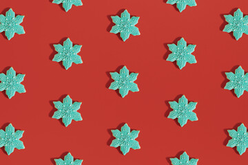 Minimal Christmas pattern made of snowflake shaped.cookies on bold red background. New Year cozy decoration. Holiday flat lay aesthetic.