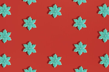 Fototapeta na wymiar Creative Christmas pattern made of snowflake shaped.cookies on bold red background. New Year cozy decoration. Holiday flat lay aesthetic. Minimal visual with copy space.