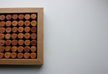 Cardboard tray with wine corks on white surface on a side of photography concept for postcard or wallpaper 
