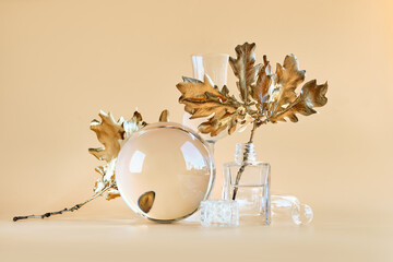 Biophilic Autumn background. Gilded gold oak leaves distorted by transparent glass jars, small...