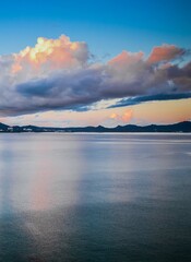 Early sunrise In August, Japan, Okinawa, Nago Clouds are reflected in the surface of the sea