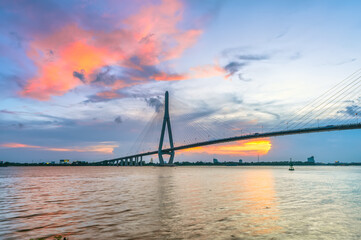 Fototapeta na wymiar Sunset Can Tho bridge, Can Tho city, Vietnam. Cable-stayed bridge connecting road traffic in Vinh Long and Can Tho provinces for trade and commerce in the Mekong Delta