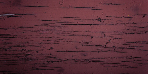 close-up rough texture of varnished wood with cracked and aged red finish
