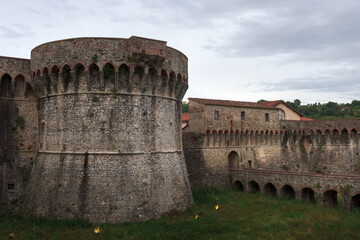 Towers and walls with bridge and moat of the medieval fortress of Firmafede in Sarzana, beautiful town in Liguria, Italy