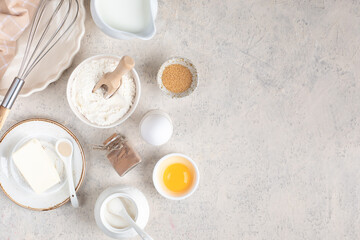 The concept of home baking. Ingredients for making dough, cake, cupcakes: eggs, flour, butter, cinnamon, milk, sugar on a light background.