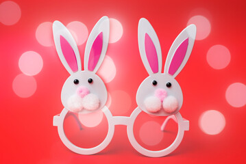 Two Toy Rabbit Bunny symbol of new year 2023 on red glowing bubbles background.Christmas or New Year concept.