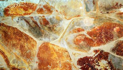 Bruchsteinmauer mit braunen und orangen Steinen als Hintergrund oder Textur