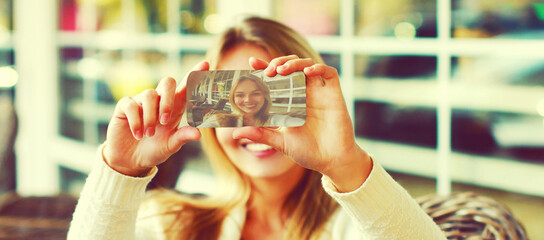 Close up young woman stretching her hands for taking selfie picture with smartphone sitting at a...