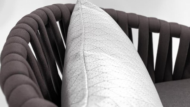 Soft white cushion rests on a beautiful designer chair. White background 