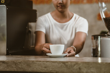 Barista serving a coffee to customer at the coffee shop.