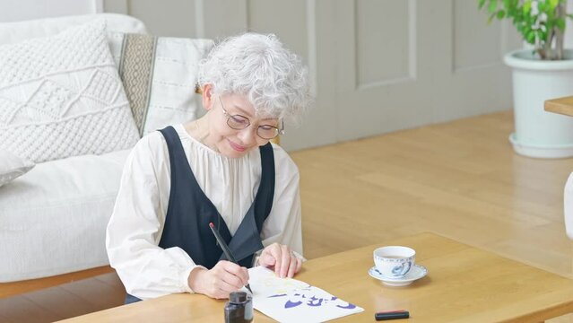 インクで文字を書くシニア女性