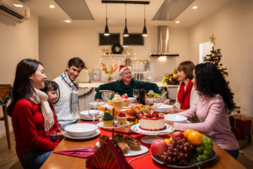 Multi-ethnic big family celebrating Christmas party together in house.