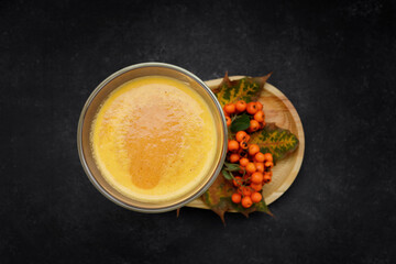 Freshly squeezed pumpkin juice with mountain ash in a glass