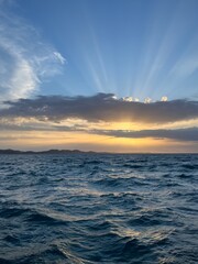 Sunset at the sea, sea horizon, sun rays through the clouds