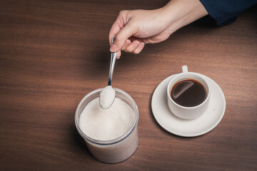 Adding sugar to a cup of black coffee