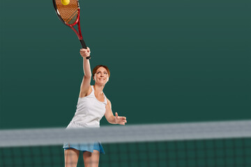 Portrait of beautiful sporty girl in white uniform serving ball during tennis game