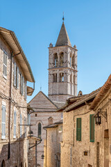 Fototapeta premium The bell tower of the basilica of Santa Chiara framed by the buildings of the historic center of Assisi, Italy