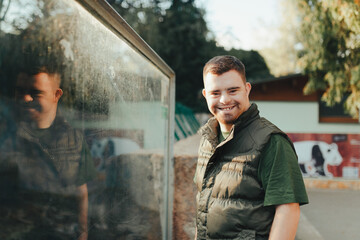 Portrait of caretaker with down syndrome in zoo. Concept of integration people with disabilities...