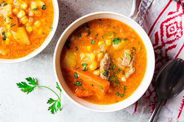 Beef meat slow-cooked soup with carrot, potato, corn and sweet potato. Winter comfort food concept.