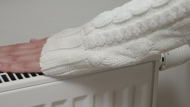 Woman with dog adjusting temperature on heating radiator, Energy crisis concept in Europe, Rising costs in private households for gas bill due to inflation and war