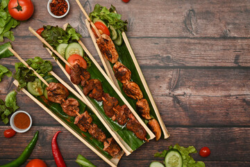 Hot and spicy and delicious street food, grilled meat with Sichuan pepper and vegetable on wooden background