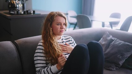Sadfemale suffer breaking up, relationship problems with boyfriend, divorce with husband, feeling heartache sitting on sofa with smartphone. Girl with unhappy expression overthinking after quarrel.
