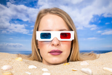 Woman buried in sand on beach with 3d glasses