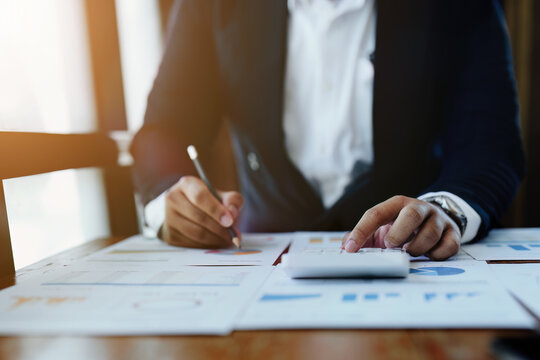 accountant, Auditor, Self-Employed, Finance and Investment, tax calculation and budget, Asian female entrepreneur using a calculator to calculate. Company business results document.