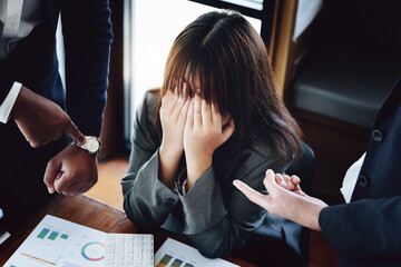 Portrait of a female worker showing failure at work and being reprimanded by a colleague
