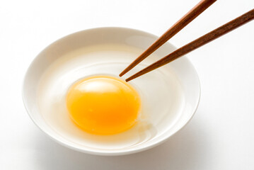 お皿に入った生卵とお箸

