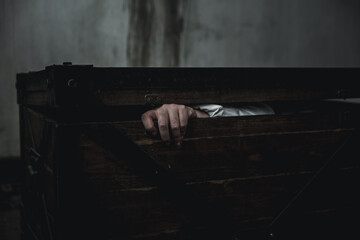 Horror ghost woman. Asian ghost horror creepy scary have hair covering face and eye lying in the old treasure chest, female makeup terror zombie face, murder, Closeup hand, Happy Halloween day concept