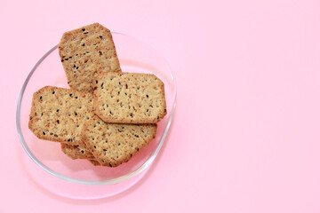 square salty diet crackers with black cumin seeds and quinoa in a glass plate