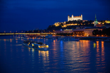 Fototapeta na wymiar Danube river cruise boat. Bratislava Castle at night