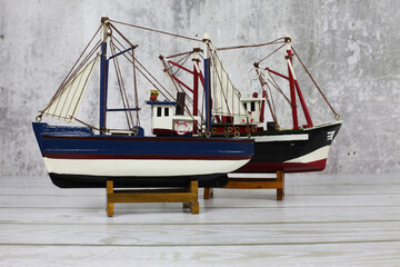 Wooden model of a fishing boat on a stand. Decoration on the shelf, collecting ships.