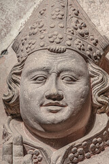 Ancient statue of a smiling and praying monk at magnificent old city Cathedral in Magdeburg, Germany. Concept historical and religious heritage.