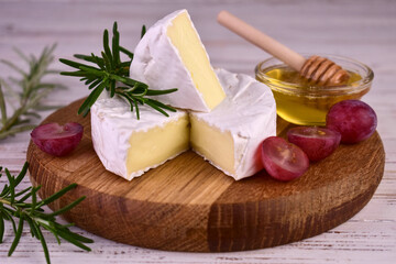 Camembert cheese in a cut on a wooden board.Close-up.

