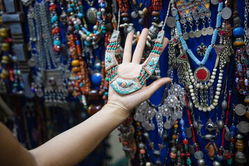 Tourist hand enjoying the pendants and handmade jewelry from the stores and street stores in the...