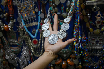 Tourist hand looking at the pendants and handmade jewelry in the stores and street stores of the city of Marrakech, where there is an endless number of handicrafts for sale typical of Morocco.