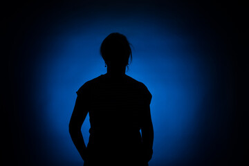 silhouette of a woman on a round blue spot on a black background