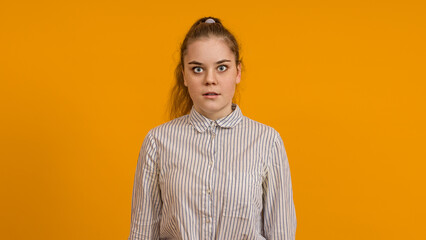 Fototapeta premium surprised young girl teenager magnified her eyes on a colored background