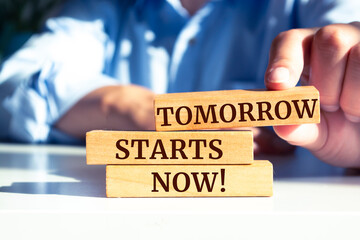 Wooden blocks with words 'Tomorrow Starts Now'.