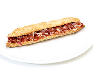 Baguette with Iberian ham on white background.  Baguette con jamón ibérico sobre fondo blanco.