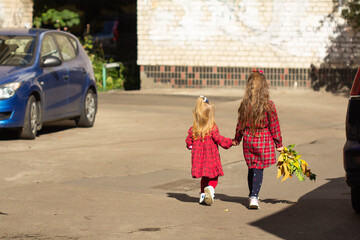 Two little girls walk through packed cars in the city of Kyiv Ukraine