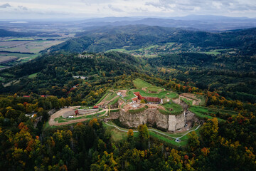 Srebrna Gora fortress and Sudety mountains at autumn season, aerial drone view. Military fort landmark for tourists in Lower Silesia, Poland - obrazy, fototapety, plakaty