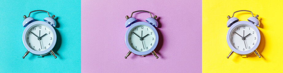 Simply minimal design three vintage classic alarm clock Isolated on colourful blue purple yellow...